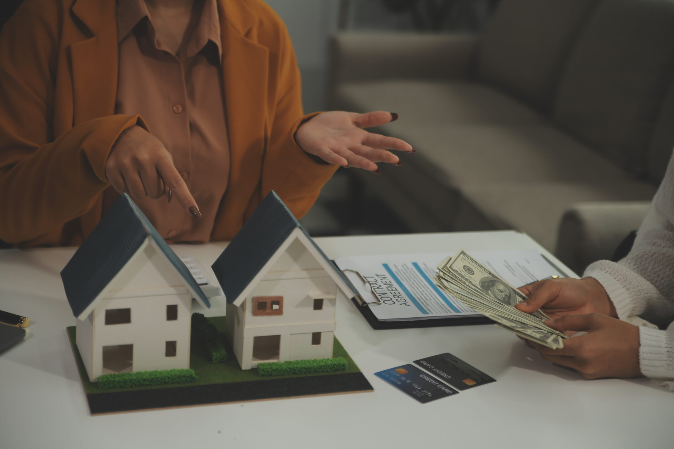 Discussion with a real estate agent, House model with agent and customer discussing for the contract to buy, get insurance or loan real estate or property.