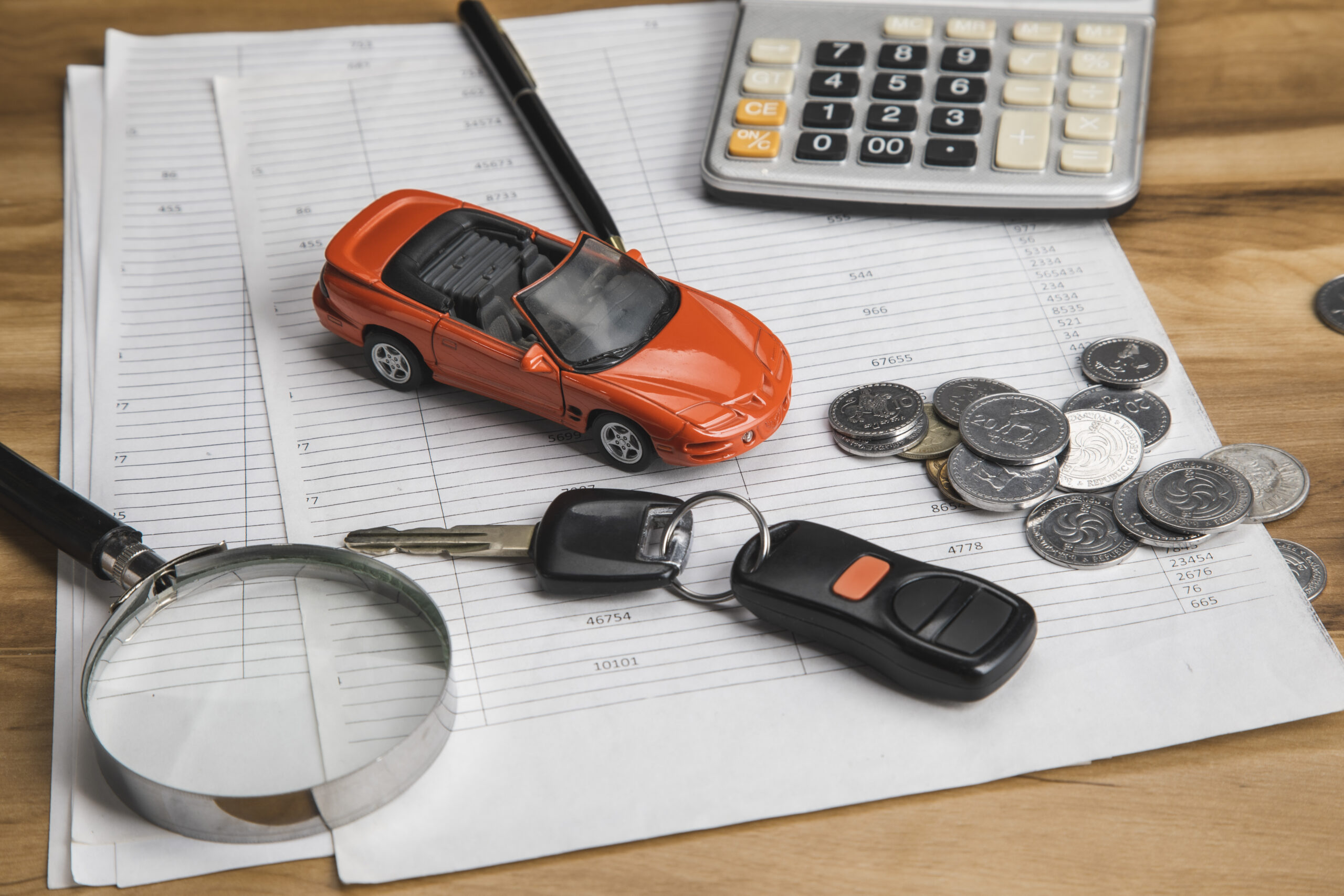 car with key and coins on document
