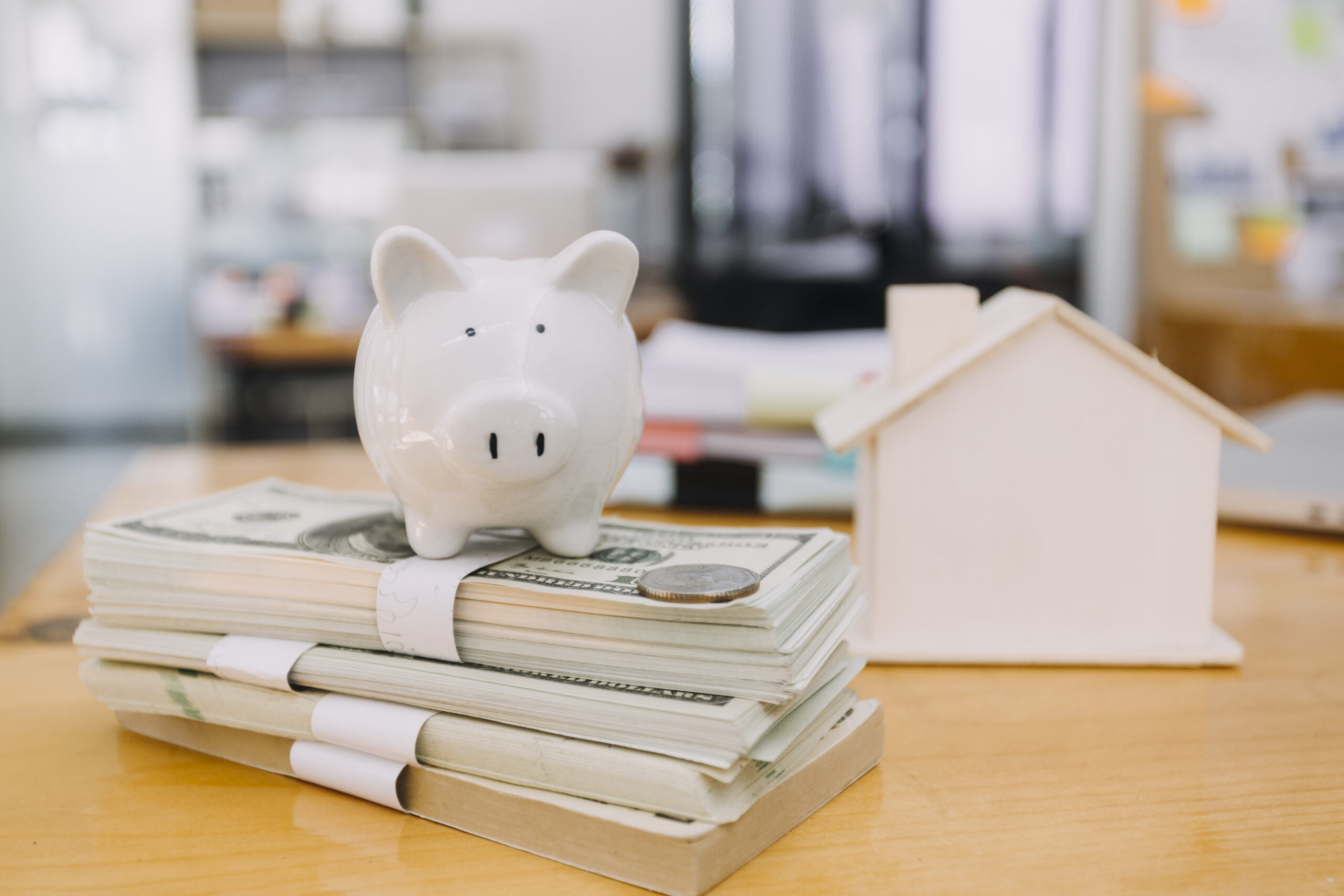 Modeling wooden houses and coins and dollars placed on wooden tables,preparation concept for house model purchase and the fastest growing real estate economy,moving home or renting property via agent